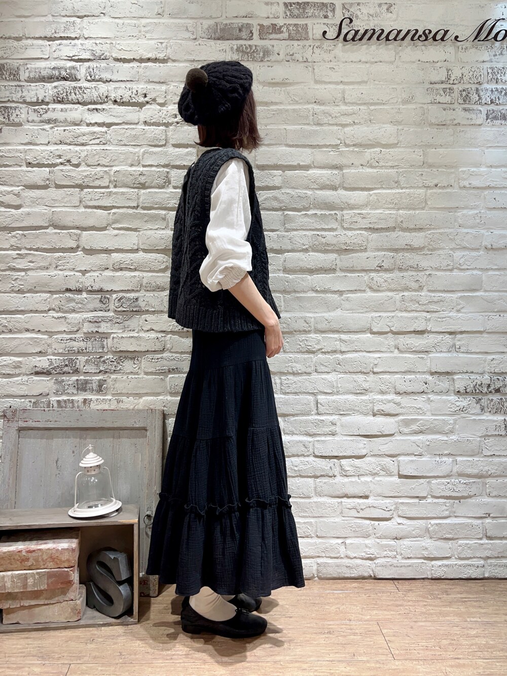 グレー系のベスト、ホワイト系のシャツ/ブラウス、ブラック系のスカートを着用したレディースの冬コーディネートの3枚目の写真