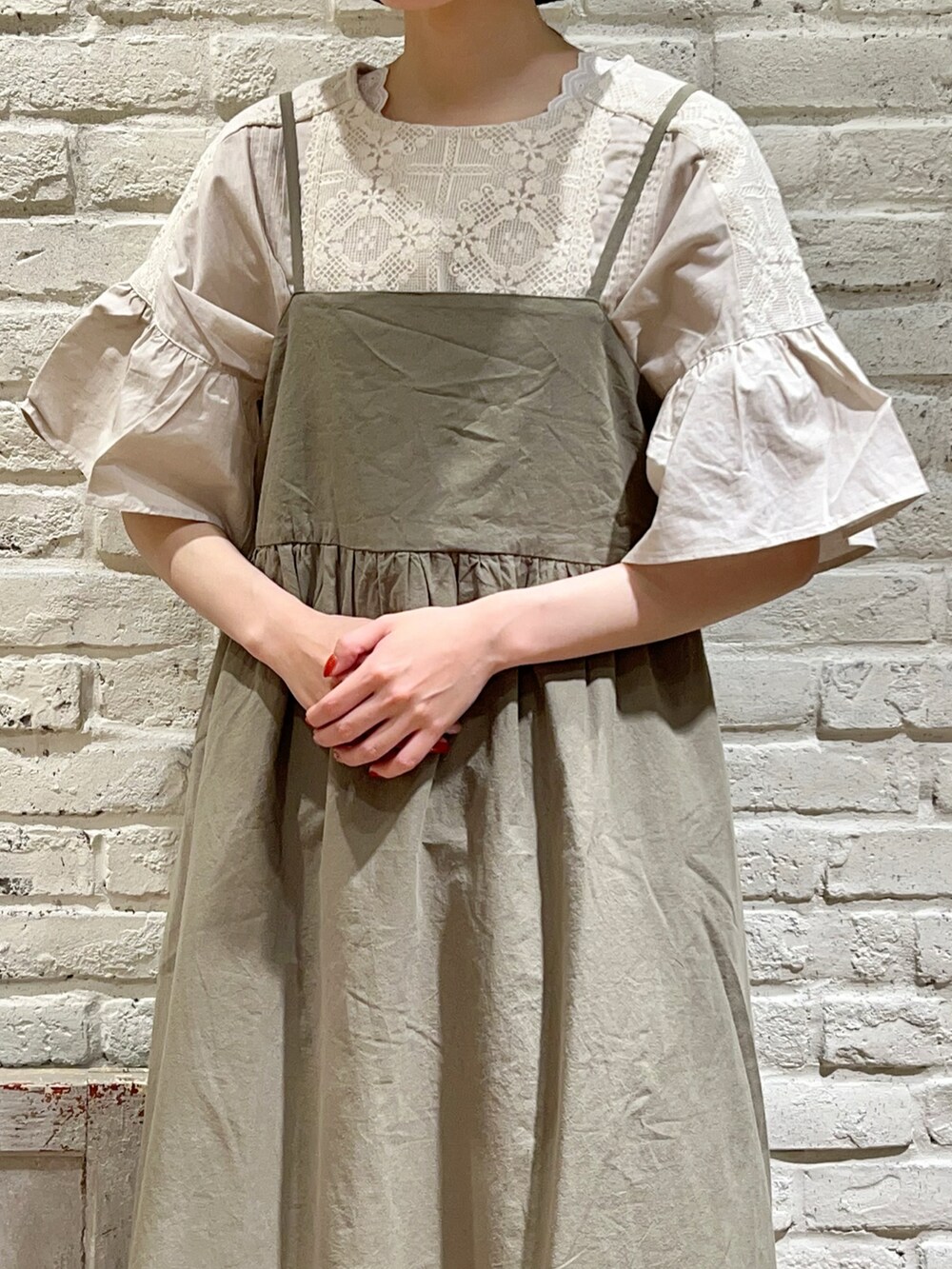 ホワイト系のタンクトップ、ホワイト系のワンピース、ベージュ系のハンドバッグを着用したレディースの夏コーディネートの2枚目の写真