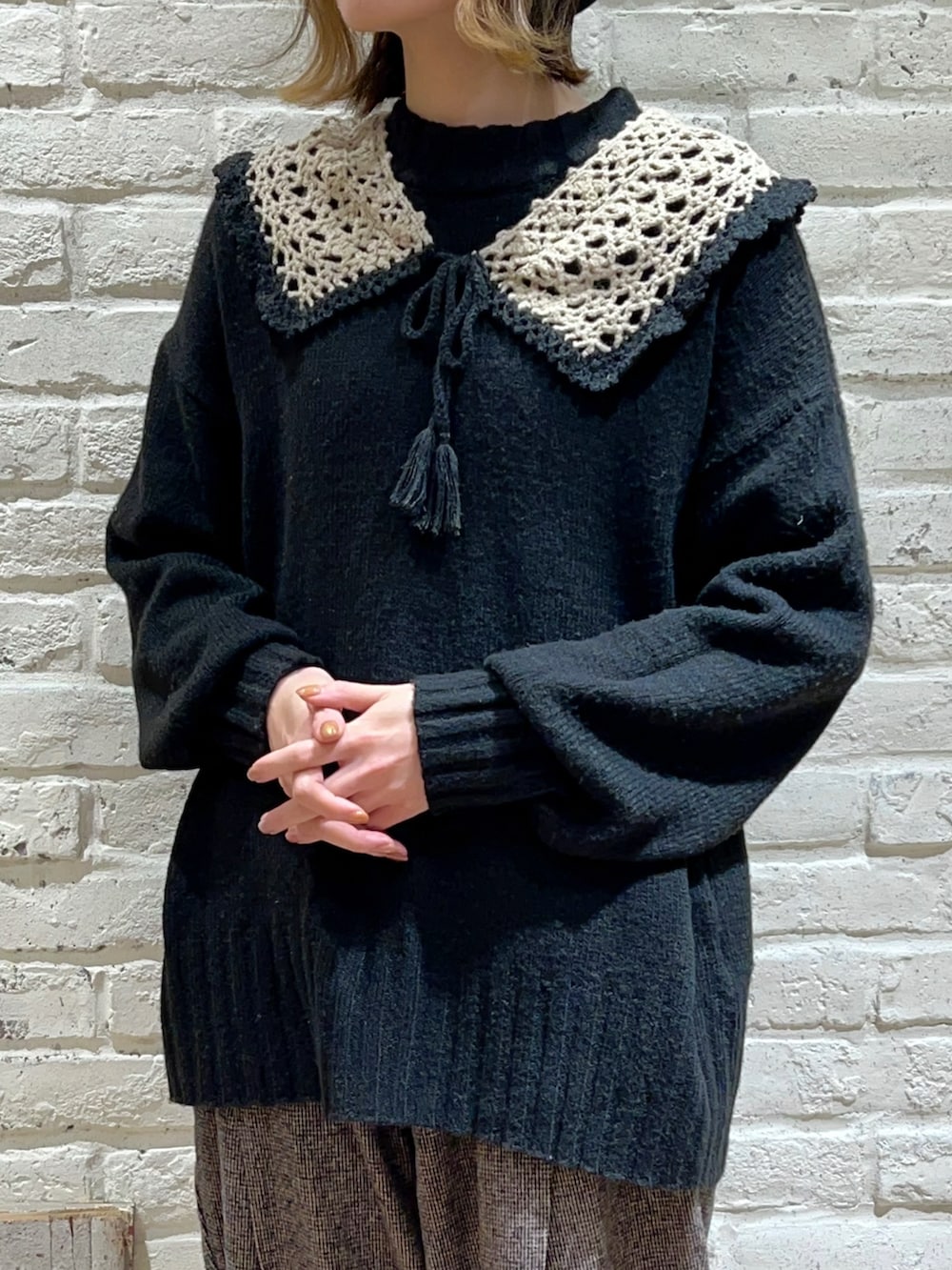 ブラック系のニット/セーター、ブラウン系のその他パンツ、ベージュ系の付け襟を着用したレディースの冬コーディネートの2枚目の写真