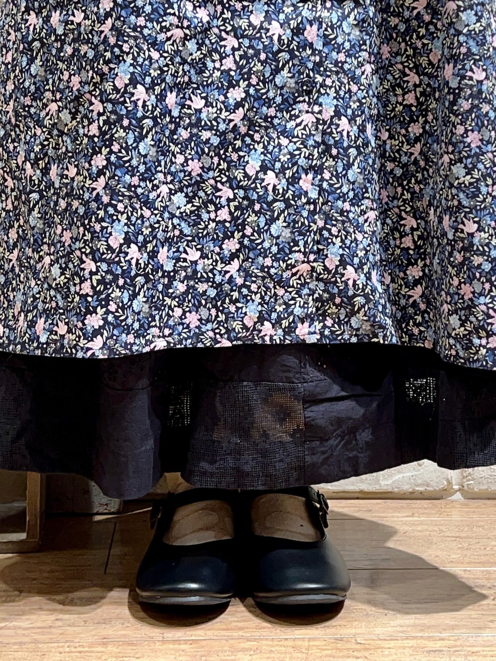 ホワイト系のタンクトップ、ピンク系のワンピース、ブラック系のスカートを着用したレディースの秋コーディネートの5枚目の写真