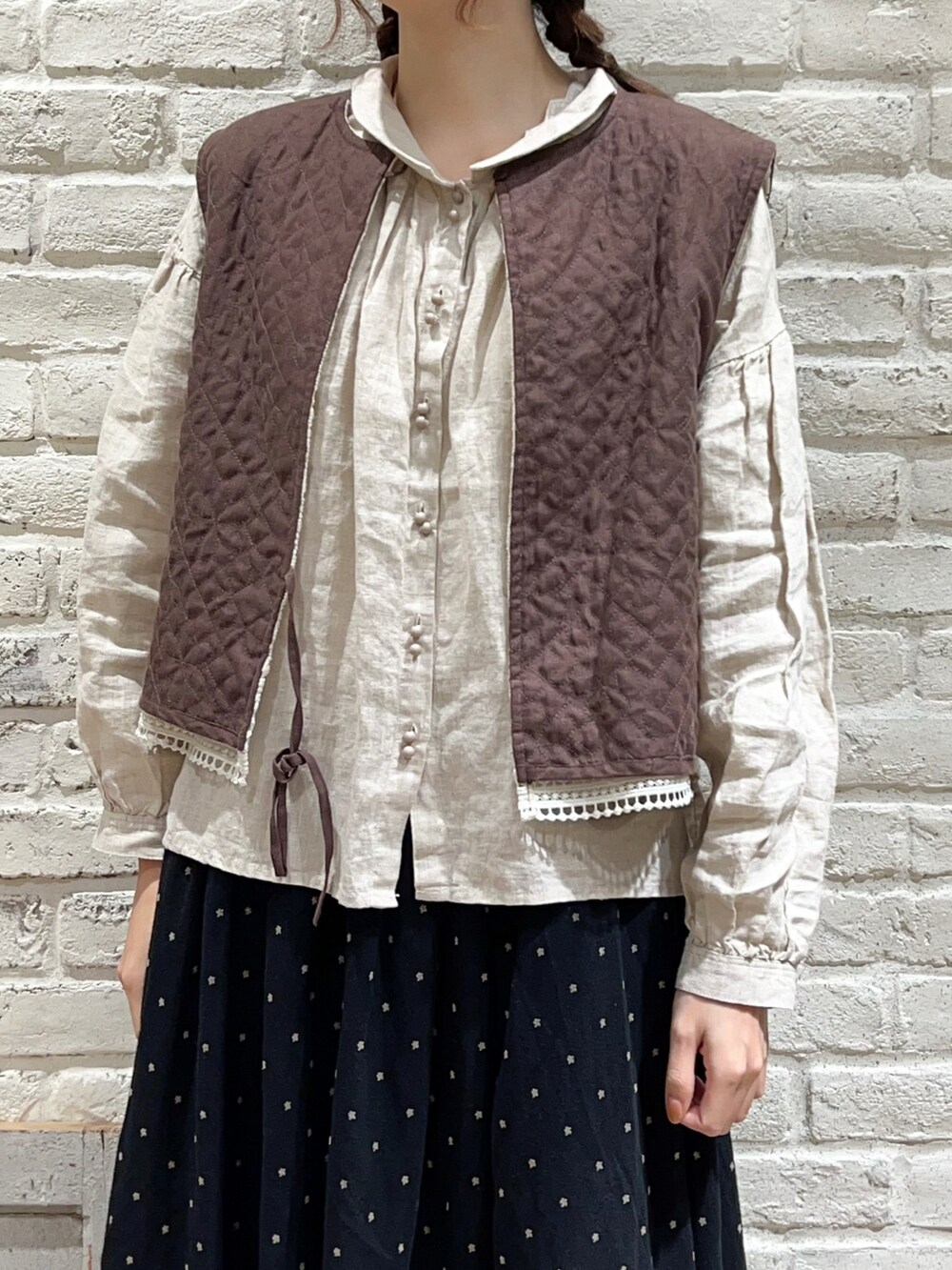 ベージュ系のシャツ/ブラウス、ブラック系のスカート、ベージュ系のドレスシューズを着用したレディースの冬コーディネートの2枚目の写真