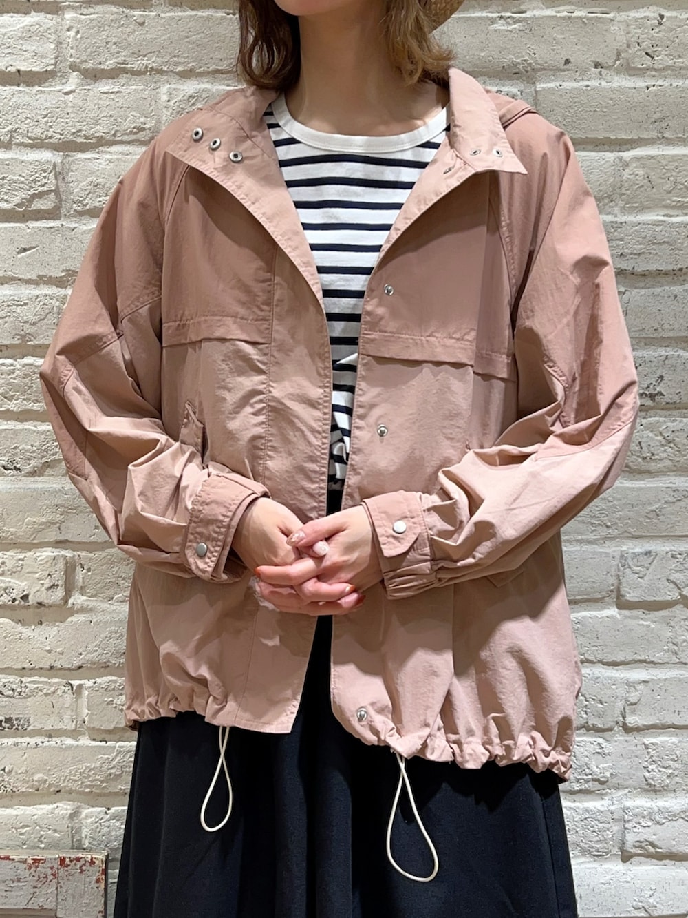 ホワイト系のTシャツ/カットソー、ピンク系のブルゾン、ベージュ系のハンドバッグを着用したレディースの春コーディネートの2枚目の写真