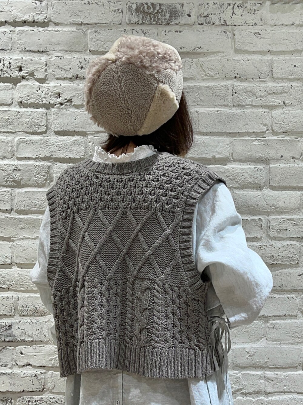 ホワイト系のTシャツ/カットソー、ブラウン系のベスト、グリーン系のワンピースを着用したレディースの冬コーディネートの4枚目の写真