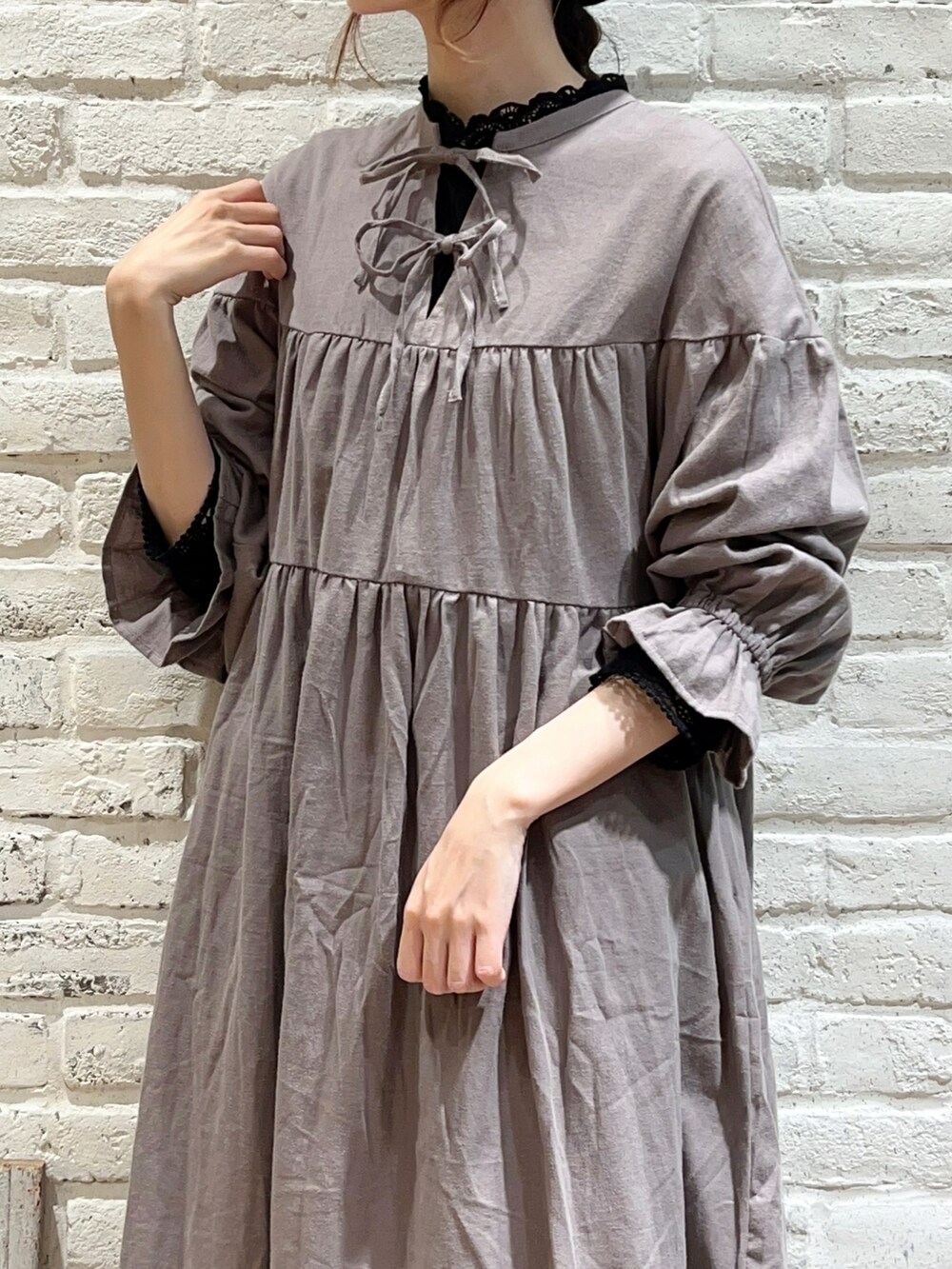 ブラック系のTシャツ/カットソー、ベージュ系のワンピース、ブラック系のスカートを着用したレディースの秋コーディネートの2枚目の写真