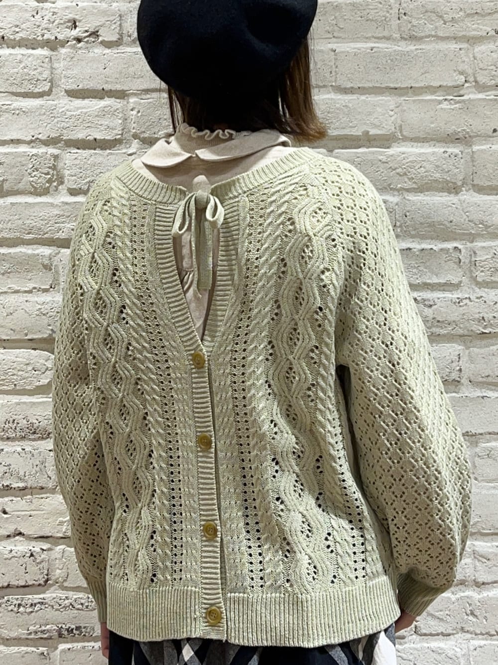 ホワイト系のシャツ/ブラウス、グリーン系のカーディガン/ボレロ、ブラウン系のショルダーバッグを着用したレディースの冬コーディネートの5枚目の写真