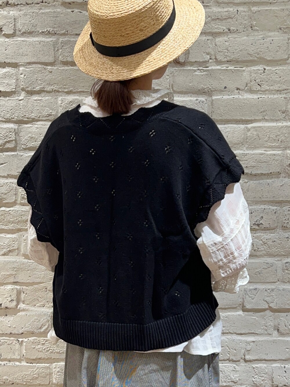 ホワイト系のシャツ/ブラウス、ブラック系のベスト、ブラック系のハンドバッグを着用したレディースの夏コーディネートの4枚目の写真