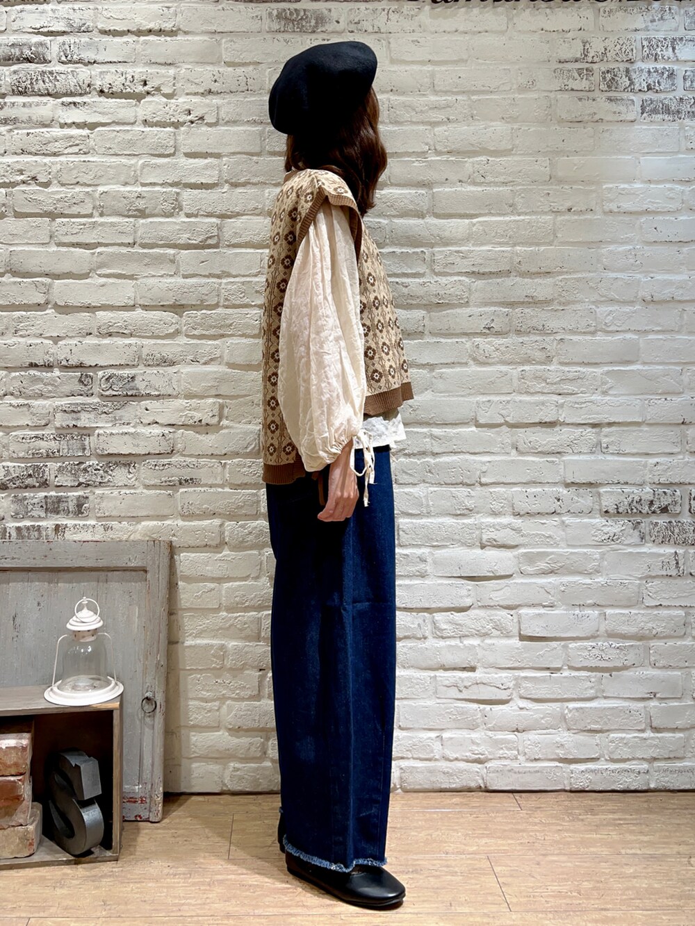 ブラウン系のベスト、ホワイト系のシャツ/ブラウス、ブルー系のデニムパンツを着用したレディースの秋コーディネートの3枚目の写真