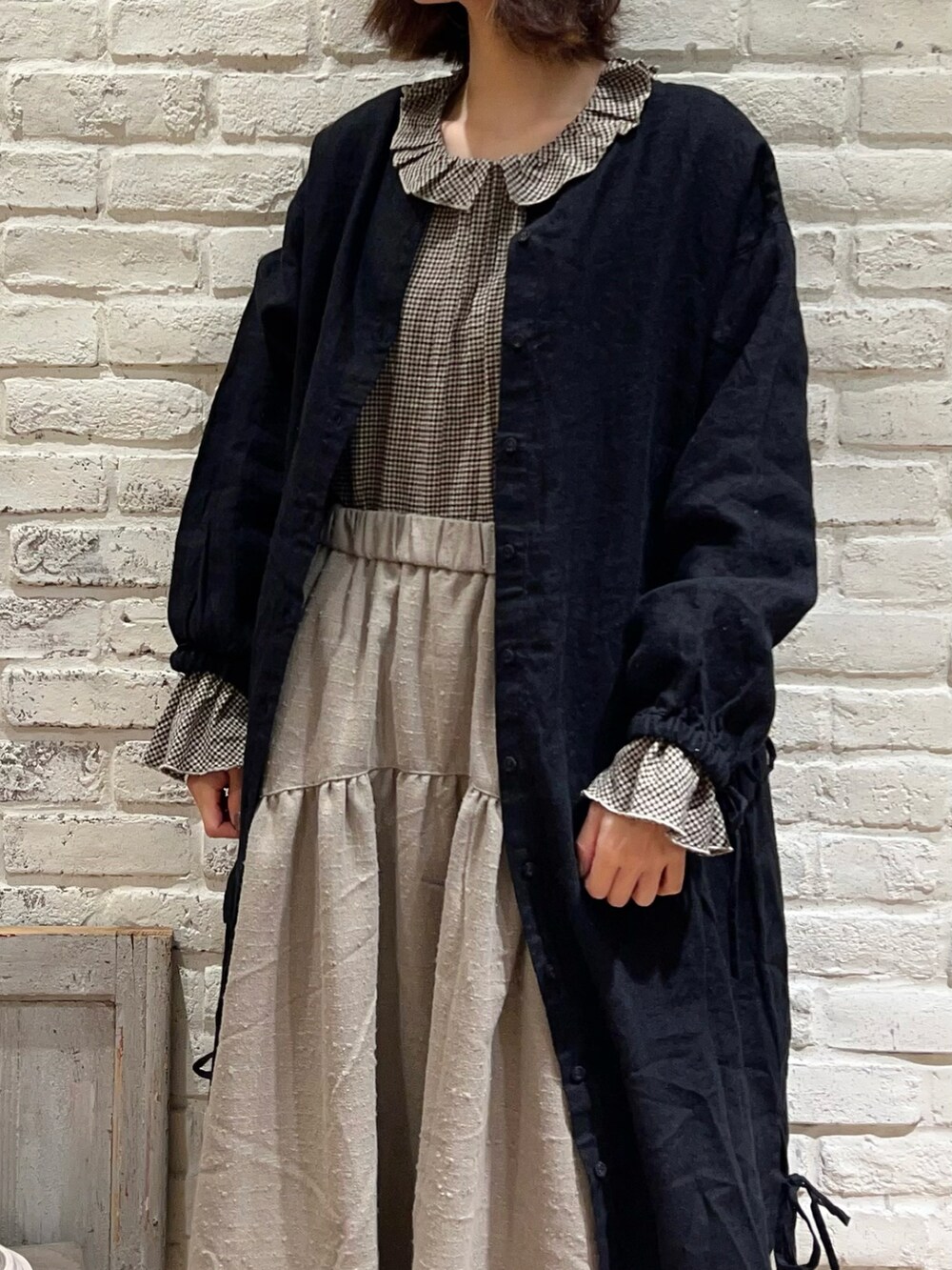 ブラウン系のシャツ/ブラウス、ブラック系のワンピース、ブラウン系のスカートを着用したレディースの冬コーディネートの2枚目の写真