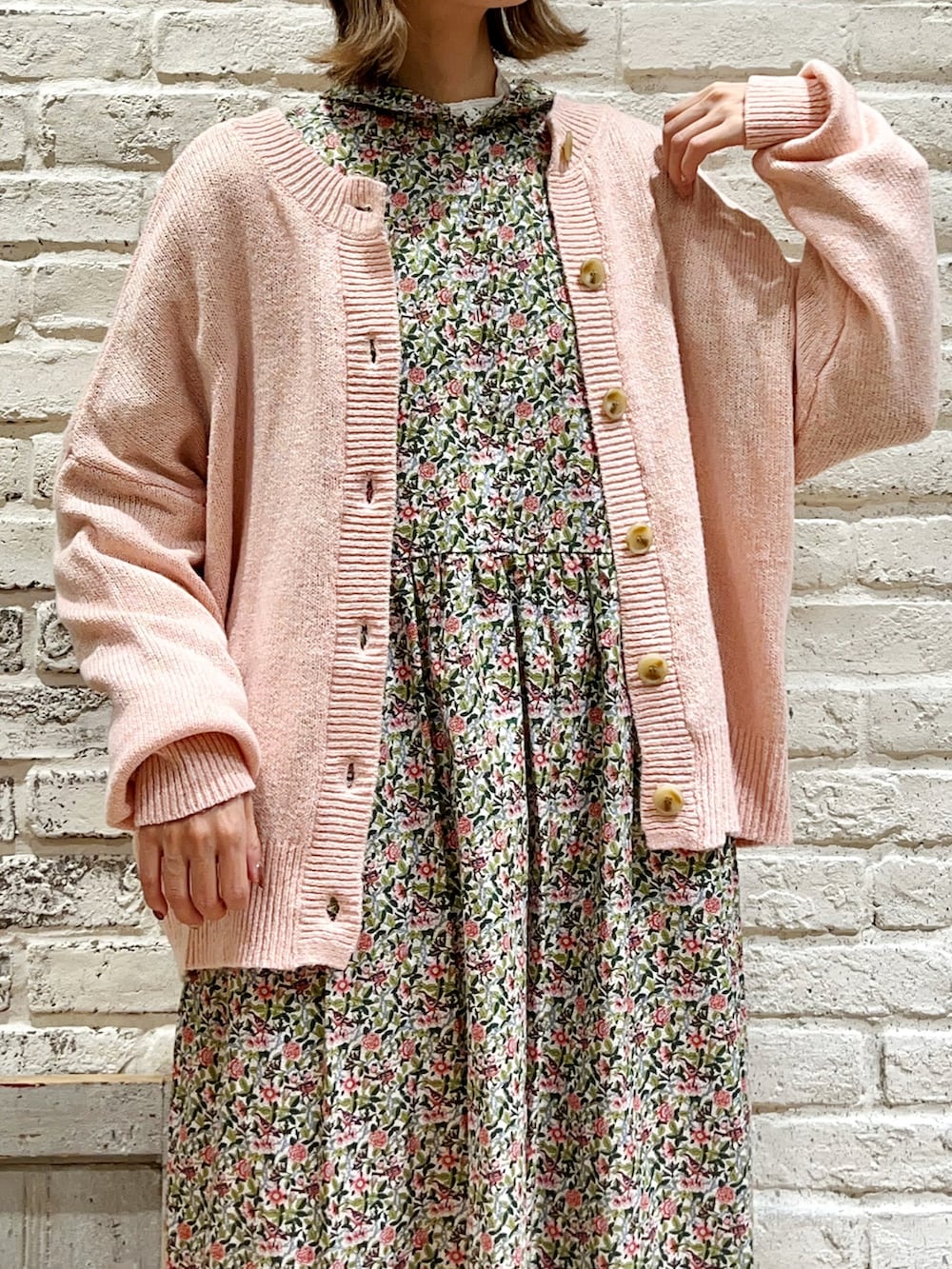 ピンク系のカーディガン/ボレロ、ピンク系のワンピース、ホワイト系のハットを着用したレディースの冬コーディネートの2枚目の写真