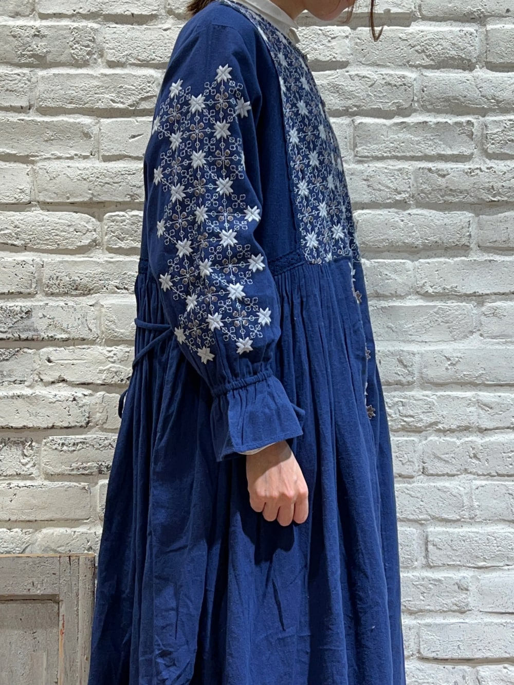 ホワイト系のシャツ/ブラウス、ブルー系のワンピース、ベージュ系のブーツを着用したレディースの冬コーディネートの3枚目の写真