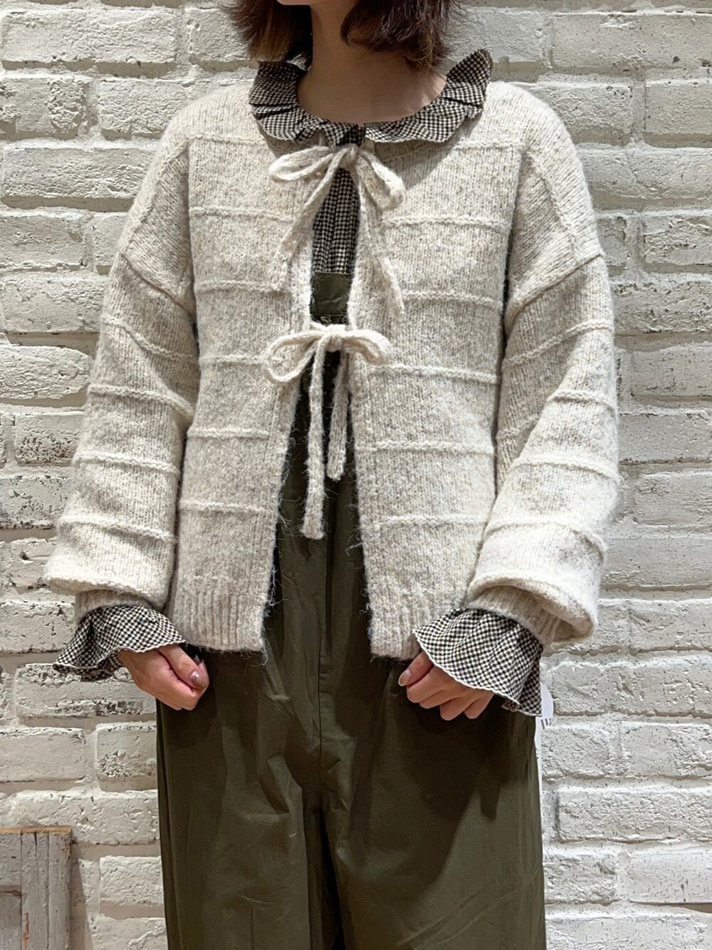 ブラウン系のシャツ/ブラウス、ホワイト系のカーディガン/ボレロ、グリーン系のサロペット/オーバーオールを着用したレディースの冬コーディネートの2枚目の写真