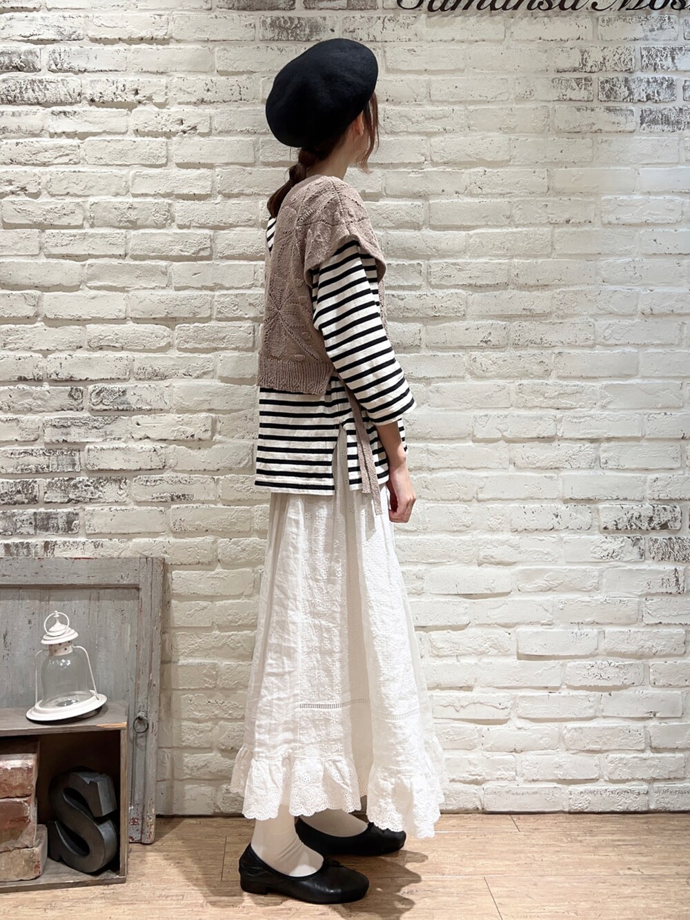 ホワイト系のTシャツ/カットソー、ベージュ系のベスト、ブラック系のハットを着用したレディースの秋コーディネートの3枚目の写真