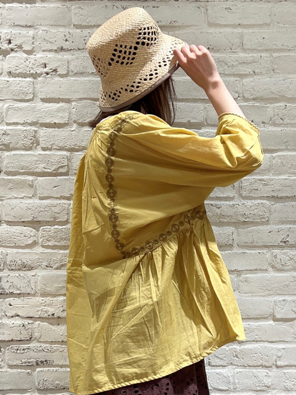 ホワイト系のタンクトップ、イエロー系のシャツ/ブラウス、ベージュ系のハンドバッグを着用したレディースの夏コーディネートの3枚目の写真