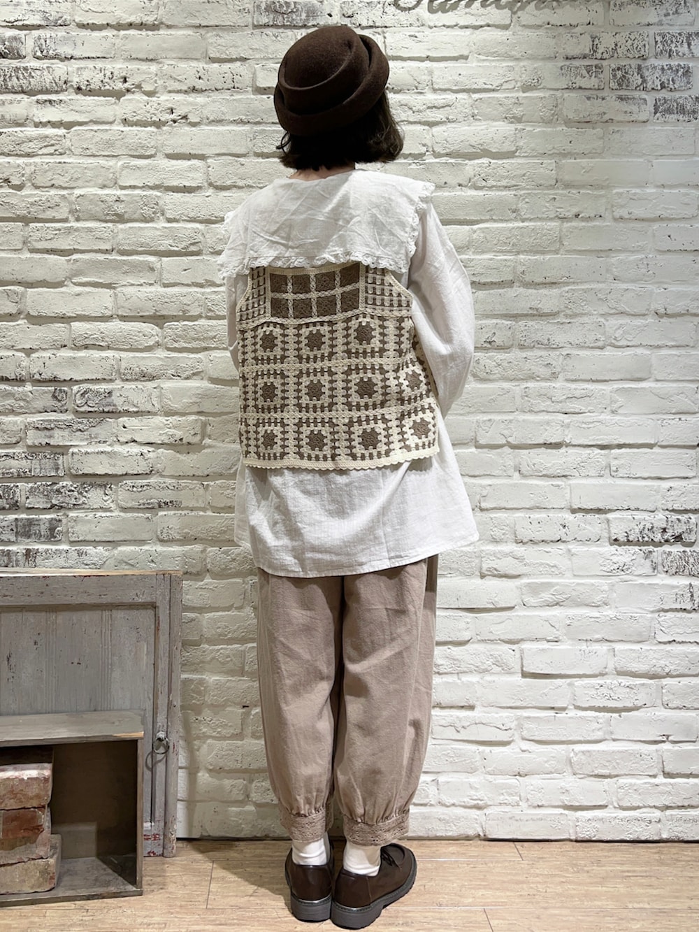 ホワイト系のチュニック、ホワイト系のベスト、ベージュ系のショルダーバッグを着用したレディースの秋コーディネートの4枚目の写真