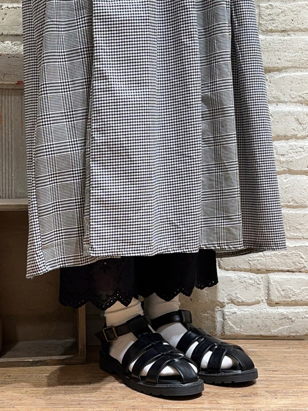 ブラック系のベスト、ブラウン系のワンピース、ブラック系のハットを着用したレディースの秋コーディネートの5枚目の写真