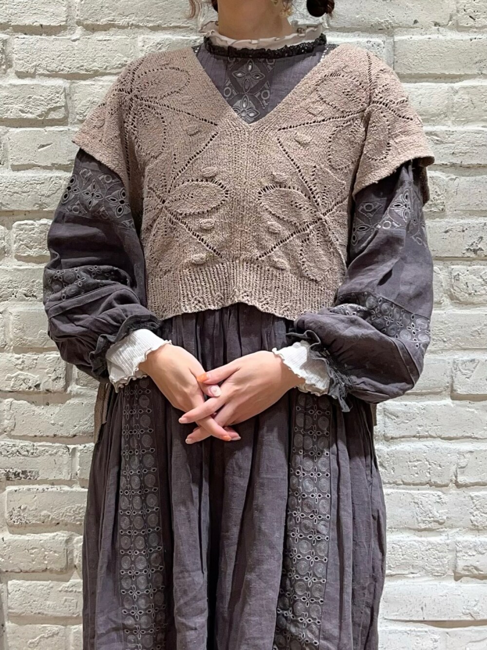 ホワイト系のTシャツ/カットソー、ベージュ系のベスト、グレー系のワンピースを着用したレディースの秋コーディネートの2枚目の写真