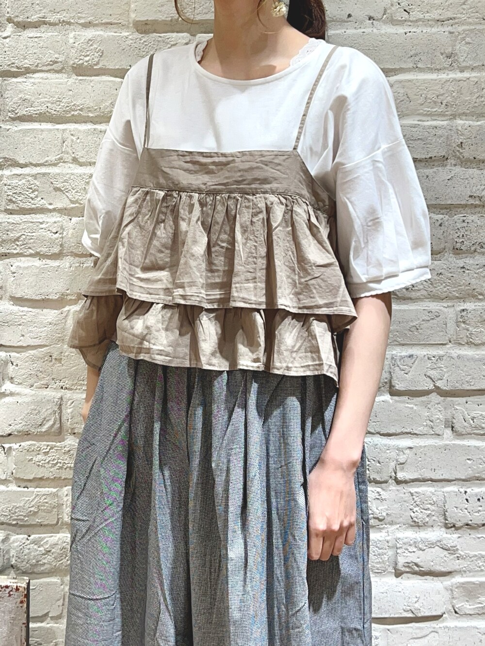 ホワイト系のTシャツ/カットソー、ベージュ系のシャツ/ブラウス、グレー系のハンドバッグを着用したレディースの秋コーディネートの2枚目の写真