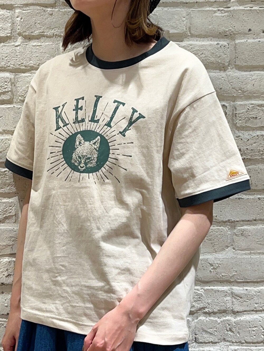 ベージュ系のTシャツ/カットソー、ブルー系のスカート、ブラック系のサンダルを着用したレディースの春コーディネートの3枚目の写真