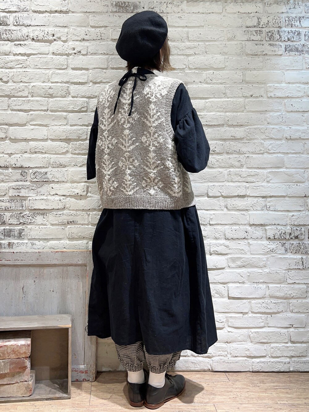 ホワイト系のTシャツ/カットソー、ブラウン系のベスト、ブラック系のワンピースを着用したレディースの冬コーディネートの3枚目の写真