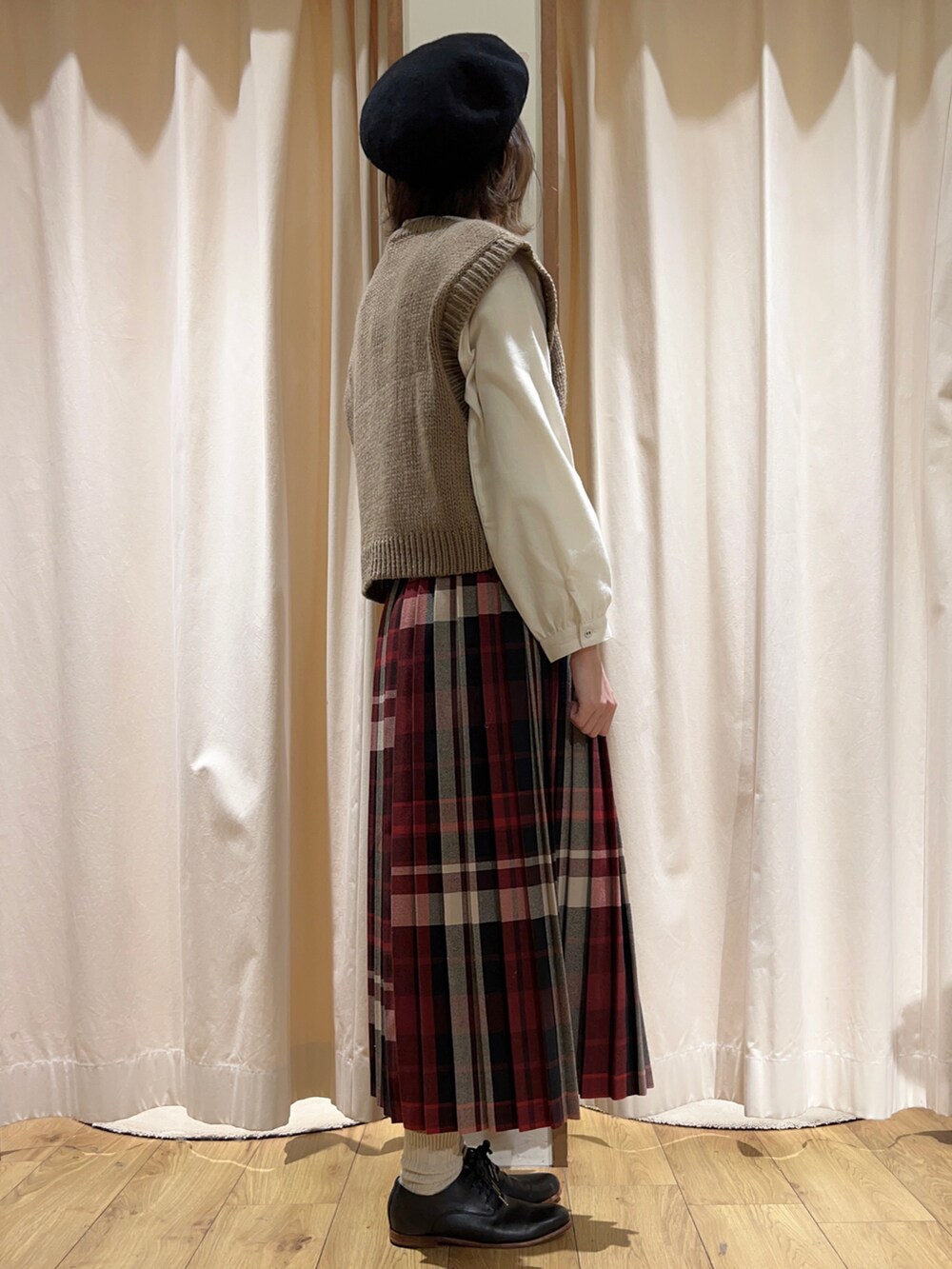 ホワイト系のニット/セーター、ブラウン系のベスト、ホワイト系のチュニックを着用したレディースの冬コーディネートの3枚目の写真