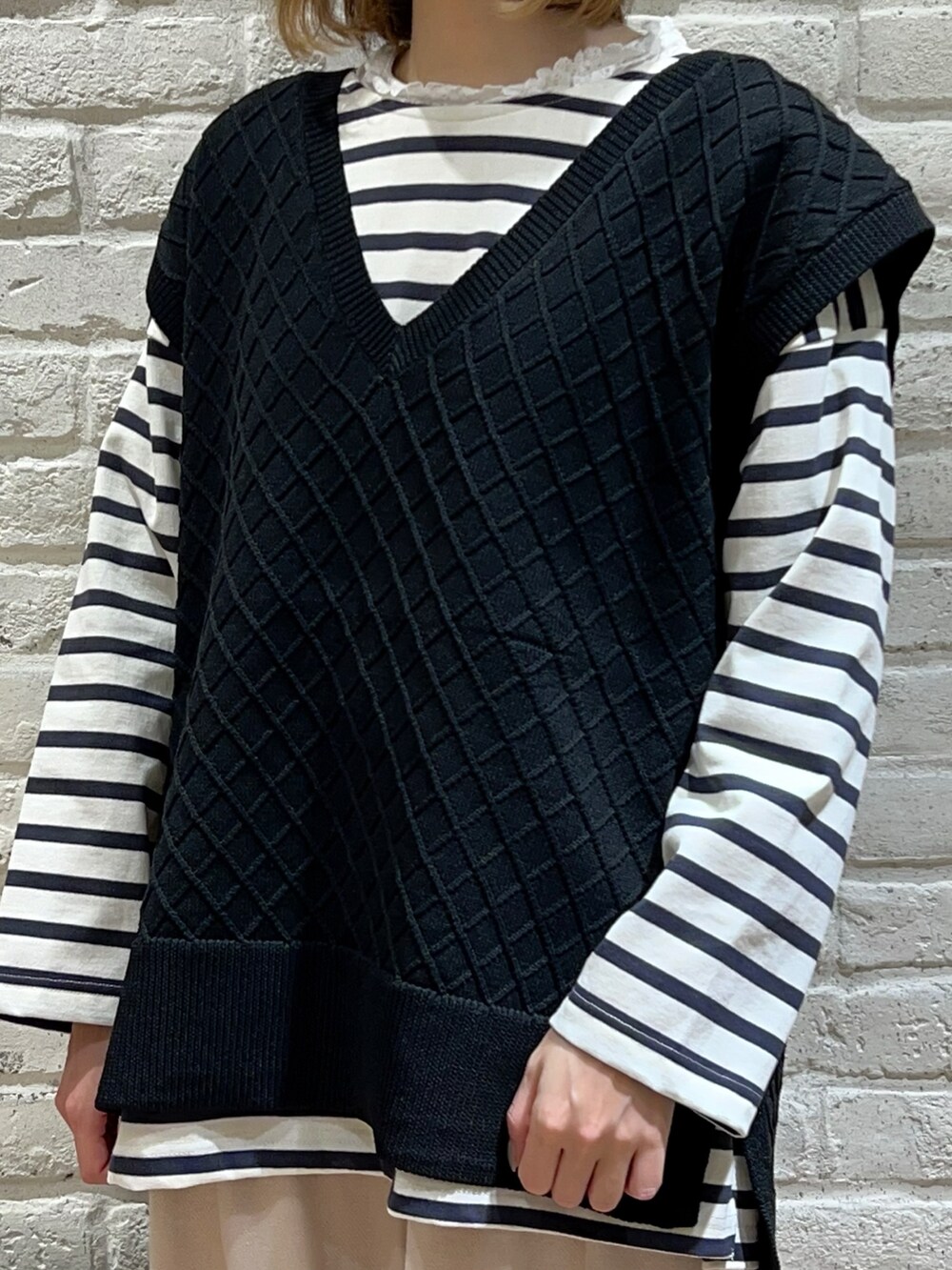 ホワイト系のTシャツ/カットソー、ブラック系のベスト、ホワイト系のTシャツ/カットソーを着用したレディースの春コーディネートの2枚目の写真