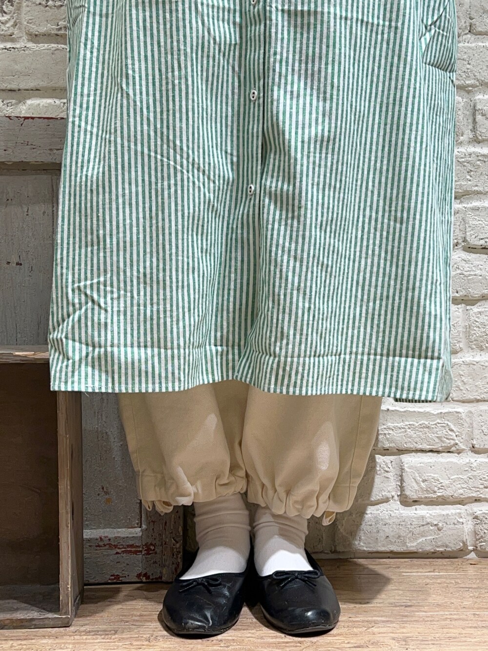 ホワイト系のニット/セーター、グリーン系のワンピース、ホワイト系のその他パンツを着用したレディースの冬コーディネートの5枚目の写真