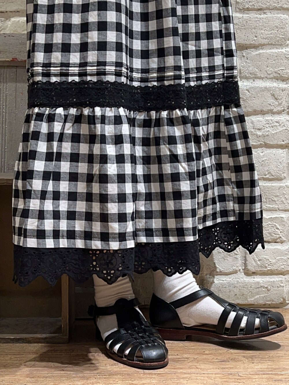 ブラック系のカーディガン/ボレロ、ホワイト系のシャツ/ブラウス、ブラック系のスカートを着用したレディースの夏コーディネートの5枚目の写真