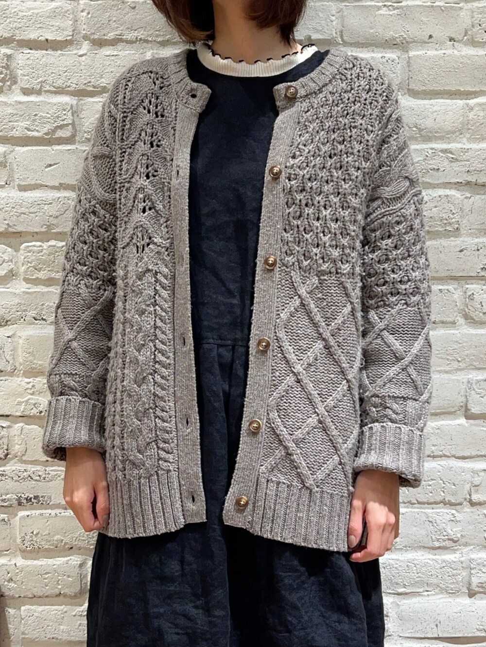 ホワイト系のTシャツ/カットソー、ブラウン系のカーディガン/ボレロ、ブラック系のワンピースを着用したレディースの冬コーディネートの2枚目の写真