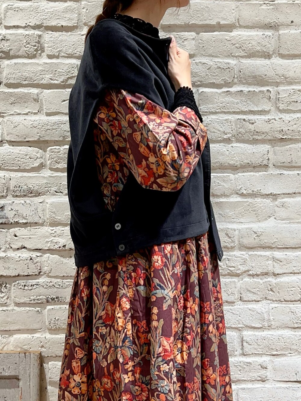 ブラック系のTシャツ/カットソー、ブラック系のベスト、ブラウン系のワンピースを着用したレディースの秋コーディネートの2枚目の写真