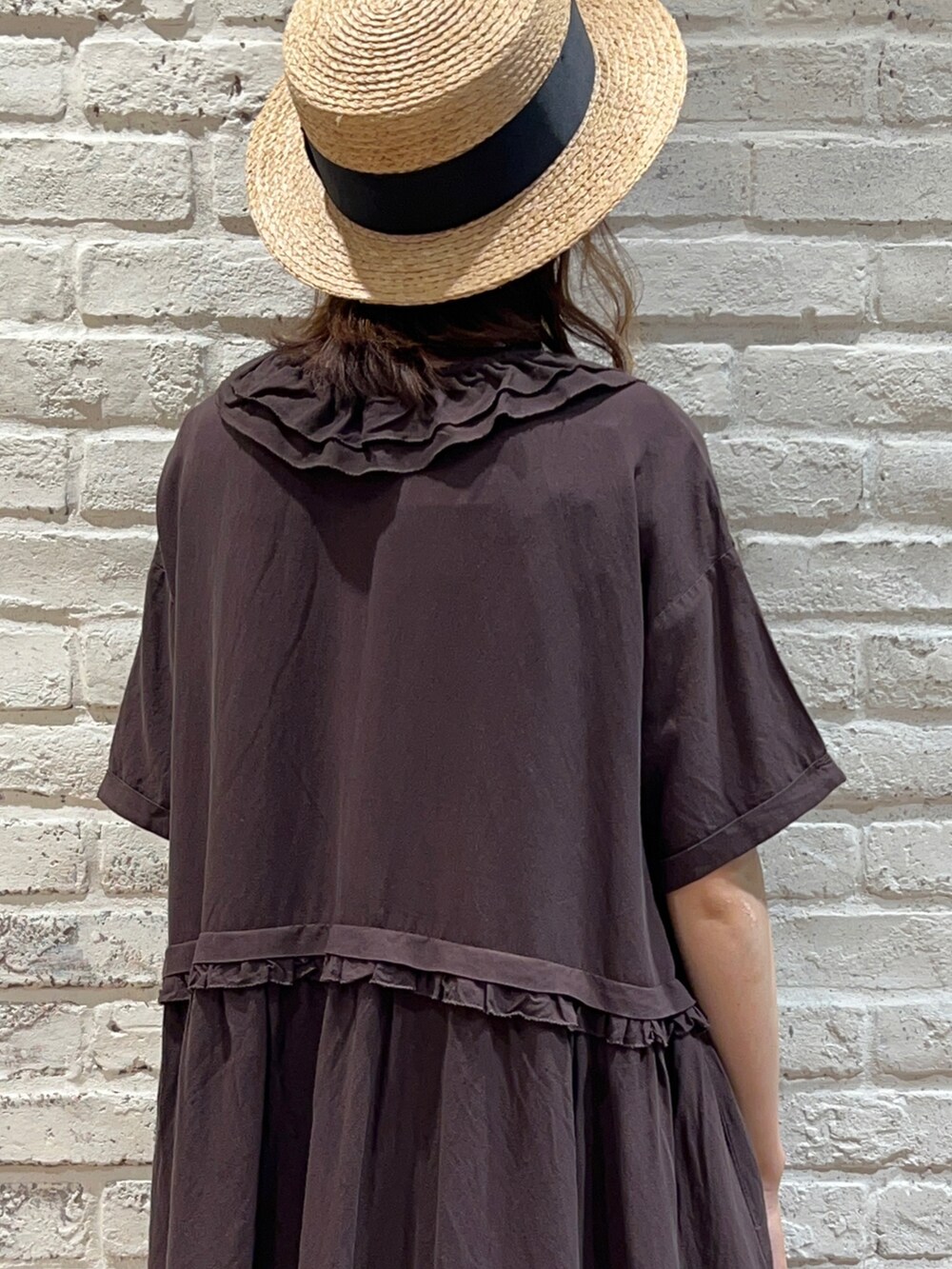 グレー系のワンピース、ブラウン系のスカート、ブラック系のサンダルを着用したレディースの春コーディネートの4枚目の写真