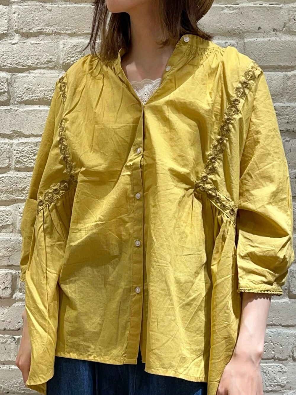 ホワイト系のタンクトップ、イエロー系のシャツ/ブラウス、ベージュ系のハンドバッグを着用したレディースの夏コーディネートの2枚目の写真