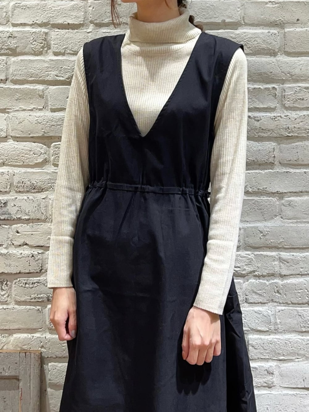 ベージュ系のブルゾン、ブラック系のワンピース、ブラック系のブーツを着用したレディースの冬コーディネートの3枚目の写真