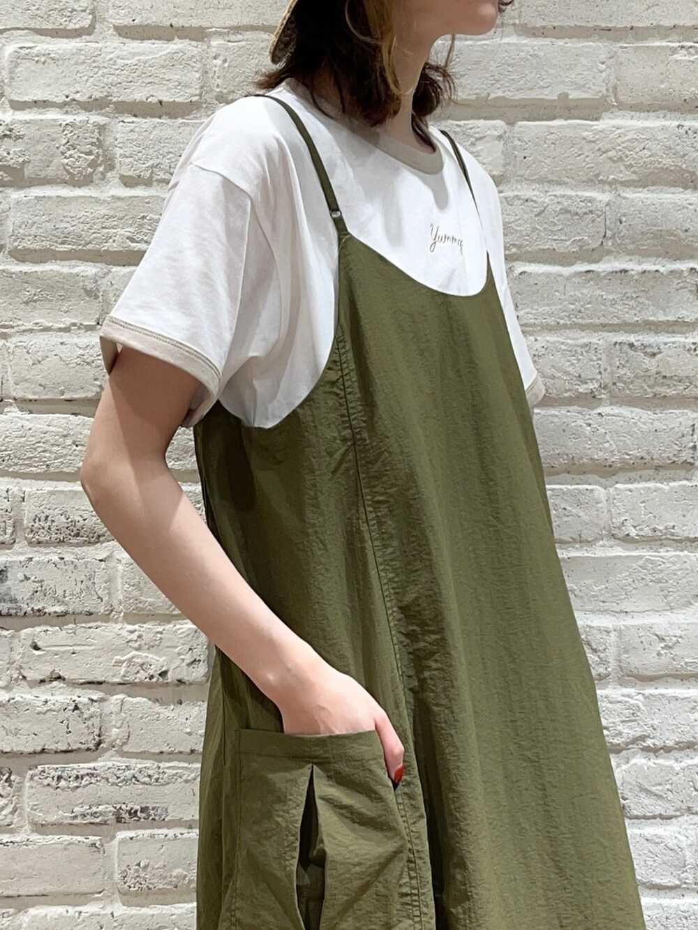 ホワイト系のTシャツ/カットソー、グリーン系のワンピース、ホワイト系のハンドバッグを着用したレディースの夏コーディネートの2枚目の写真