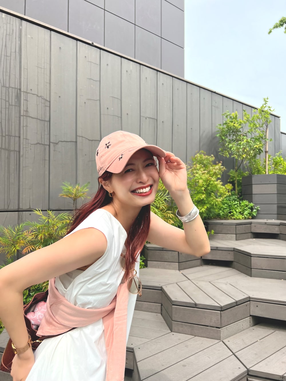 ブラウン系のバッグ、ホワイト系のワンピース、ブラウン系のサンダルを着用したレディースの夏コーディネートの2枚目の写真