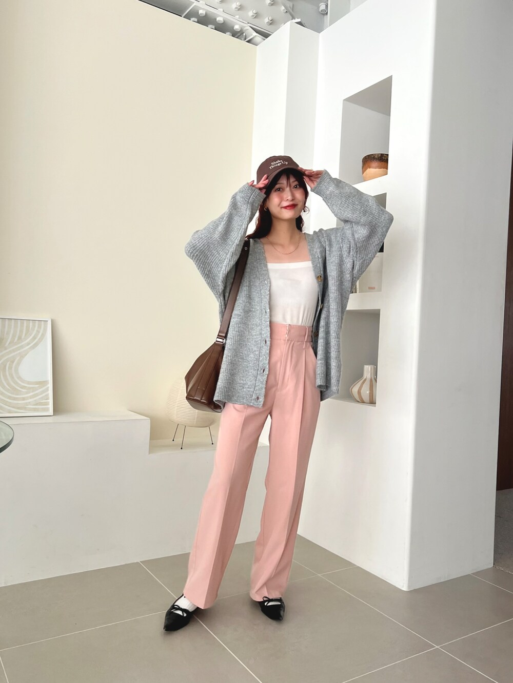 ブラウン系のバッグ、ピンク系のスラックス、ブラック系のパンプスを着用したレディースの秋コーディネートの3枚目の写真