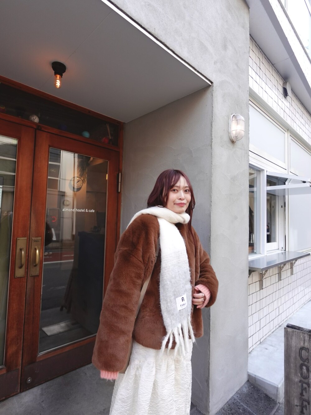 ホワイト系のスカート、ブラウン系のブーツ、ピンク系のニット/セーターを着用したレディースの冬コーディネートの2枚目の写真