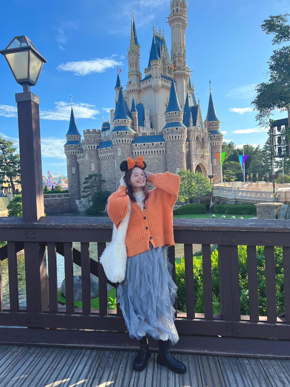 ホワイト系のショルダーバッグ、ブラック系のブーツを着用したレディースの秋コーディネートの2枚目の写真