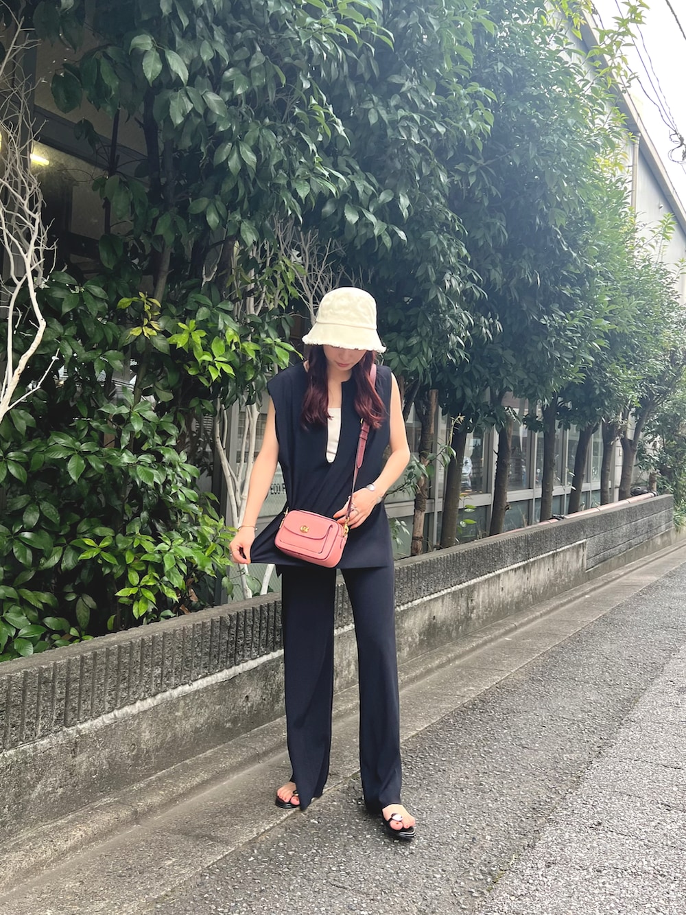 ピンク系のショルダーバッグ、ブラック系のベスト、ブラック系のその他パンツを着用したレディースの夏コーディネートの3枚目の写真