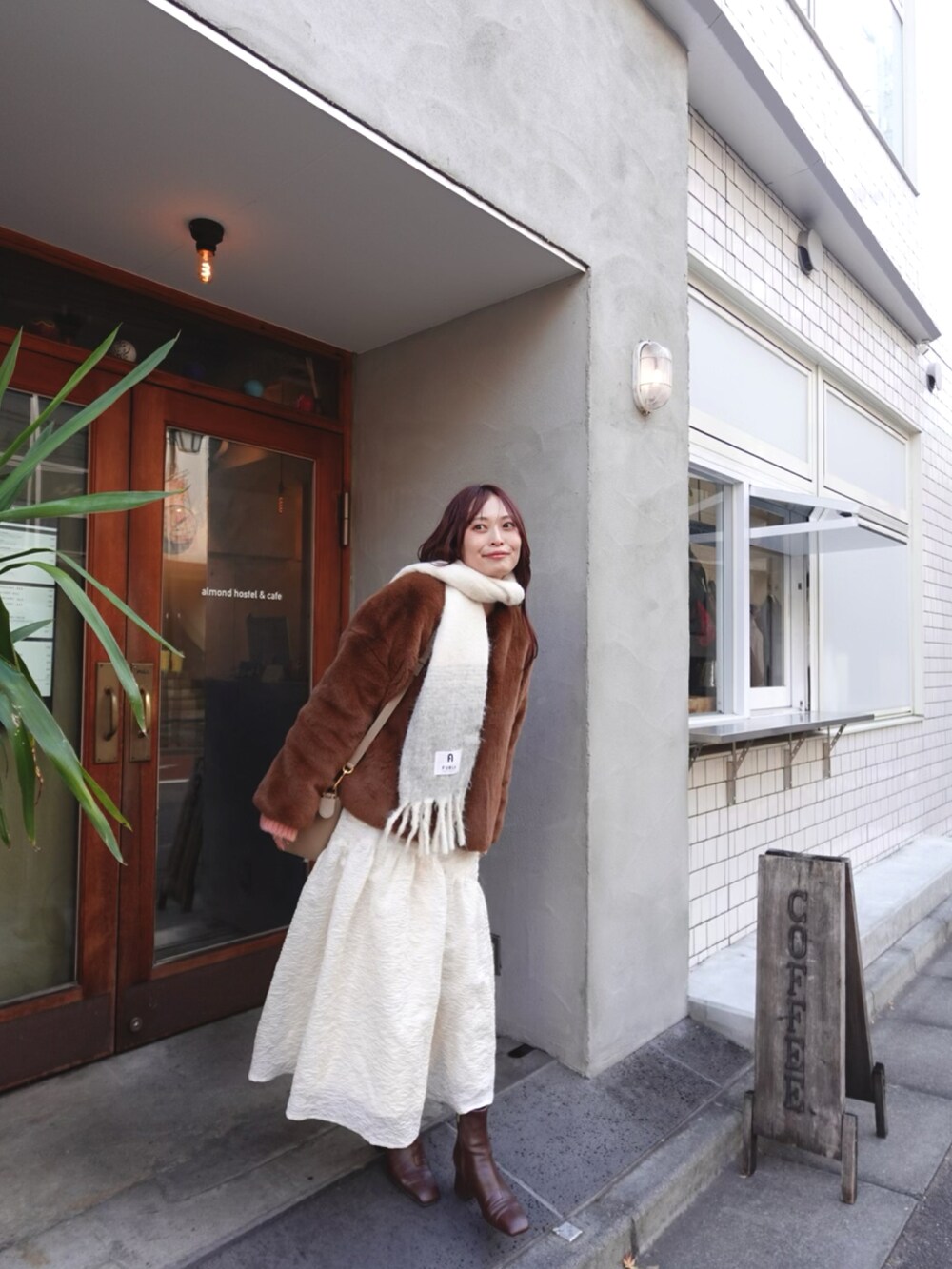 ホワイト系のスカート、ブラウン系のブーツ、ピンク系のニット/セーターを着用したレディースの冬コーディネートの3枚目の写真