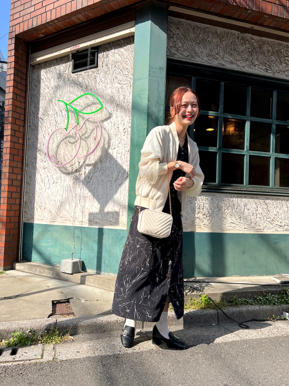 ブラック系のワンピース、ブラック系のパンプス、レッド系の口紅/リップティント/グロスを着用したレディースの春コーディネートの4枚目の写真