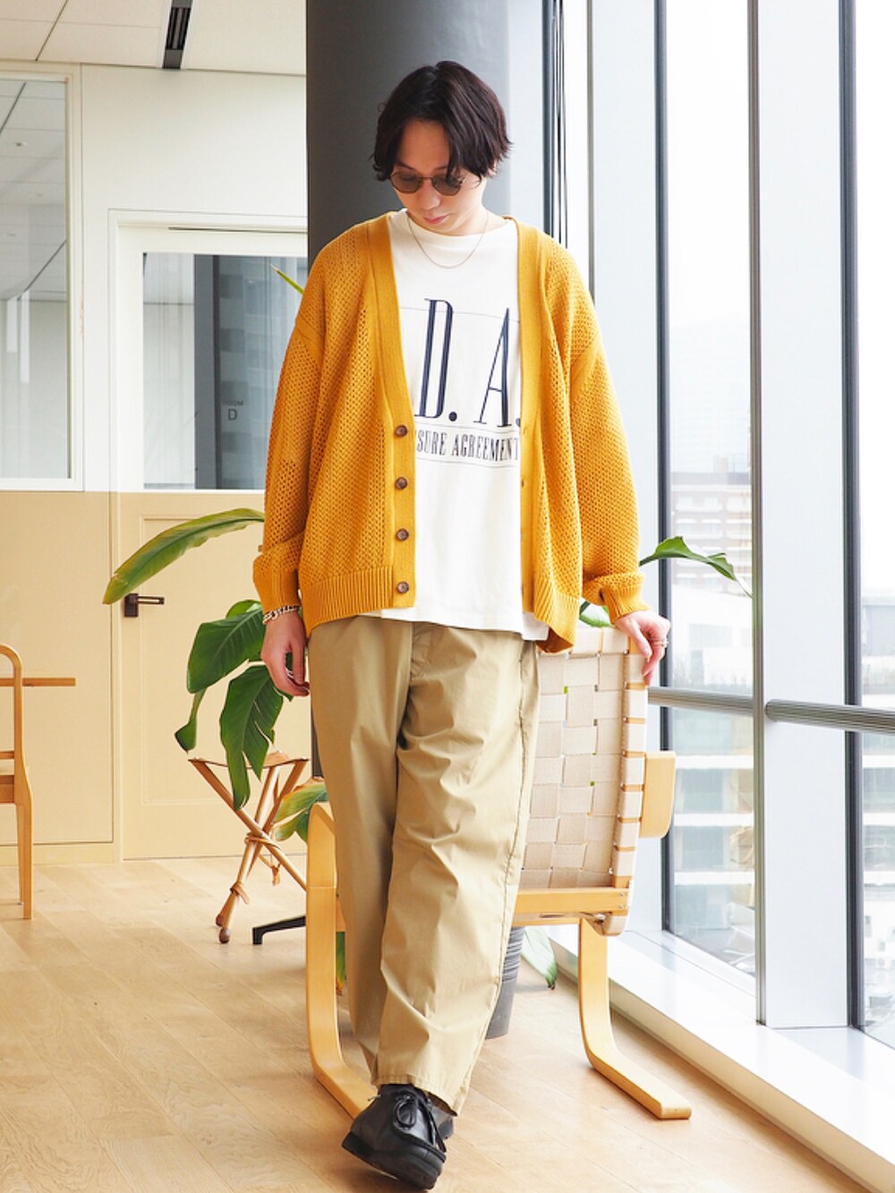 イエロー系のニット/セーター、ホワイト系のTシャツ/カットソー、ブラック系のブーツを着用したメンズの冬コーディネートの3枚目の写真