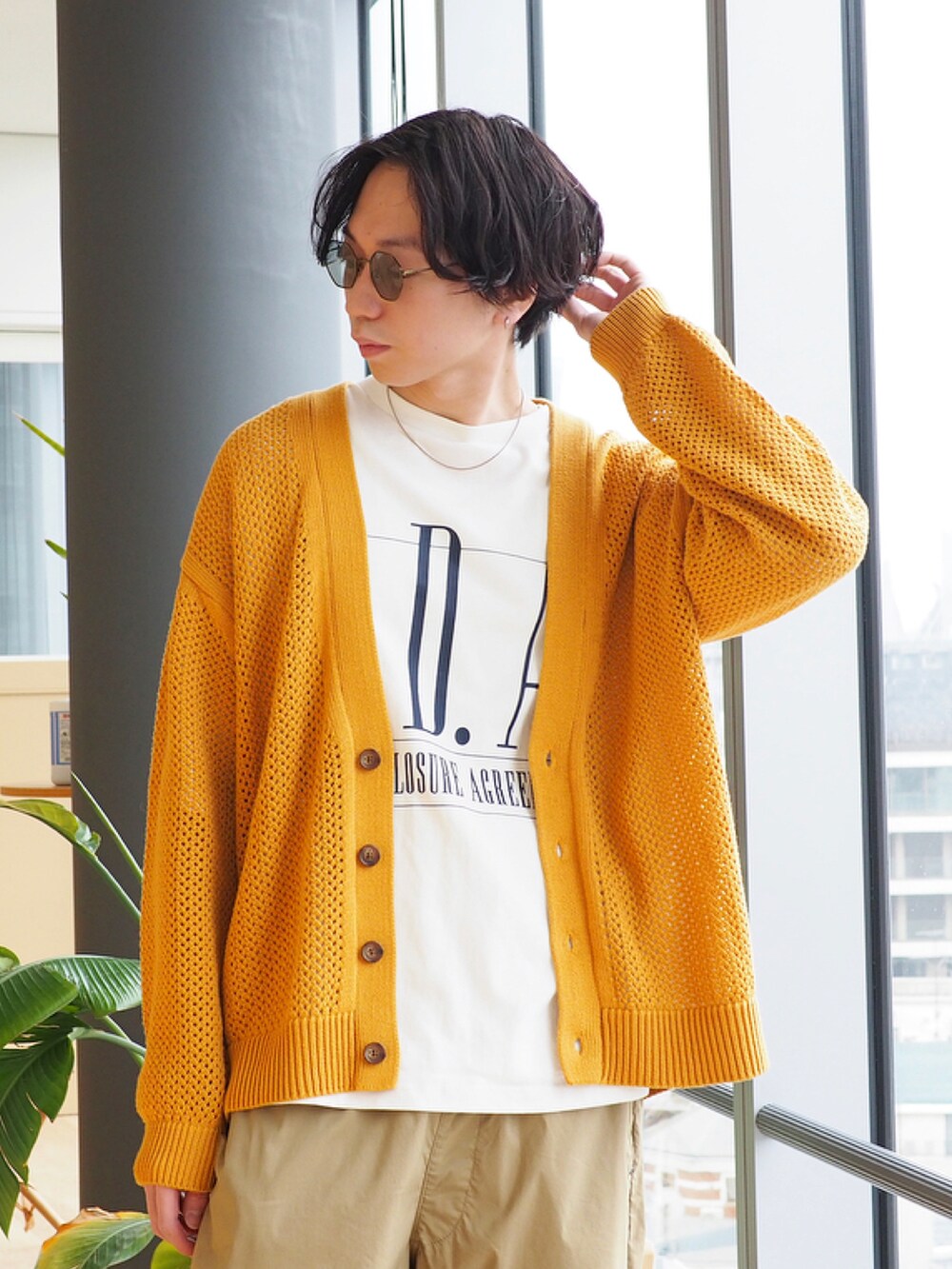 イエロー系のニット/セーター、ホワイト系のTシャツ/カットソー、ブラック系のブーツを着用したメンズの冬コーディネートの4枚目の写真