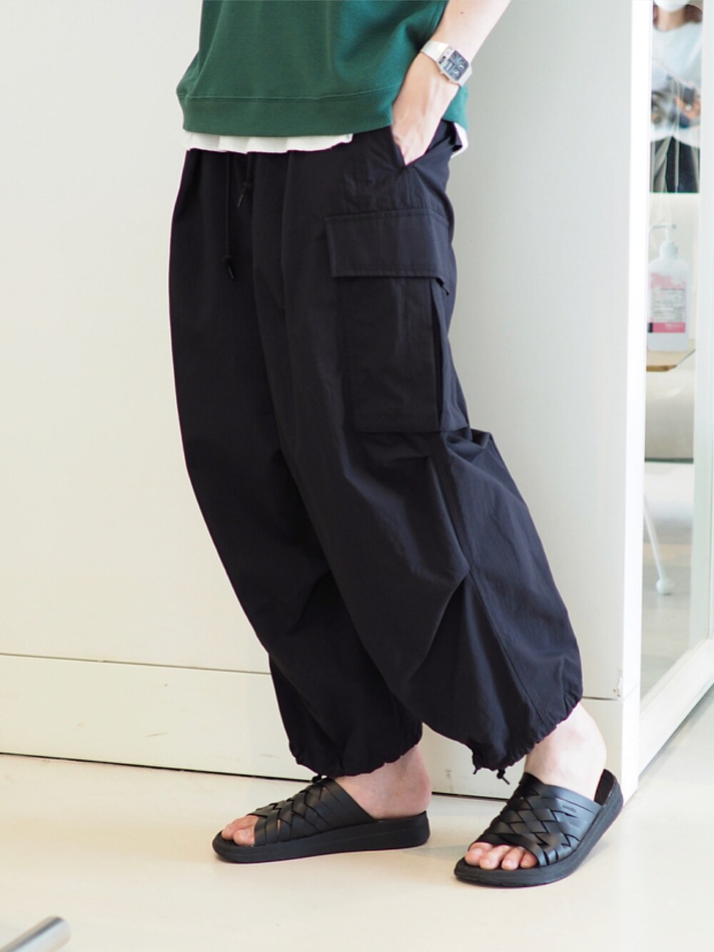 グリーン系のTシャツ/カットソー、ブラック系のカーゴパンツ、ブラック系のサンダルを着用したメンズの春コーディネートの3枚目の写真