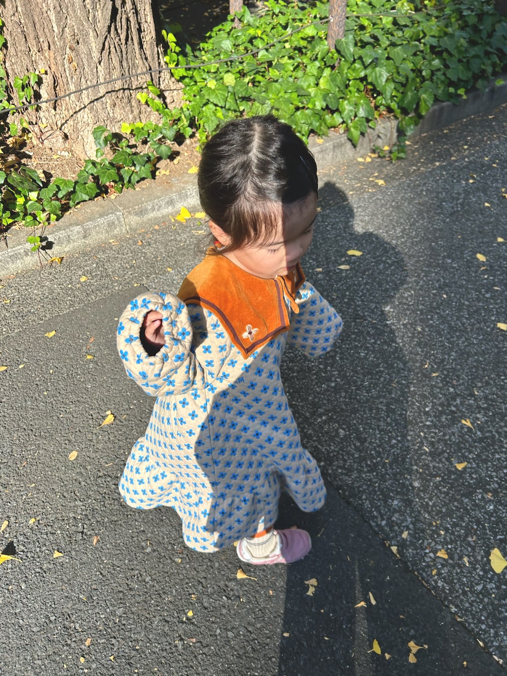 ベージュ系のワンピース、ピンク系のスニーカーを着用したキッズの冬コーディネートの2枚目の写真