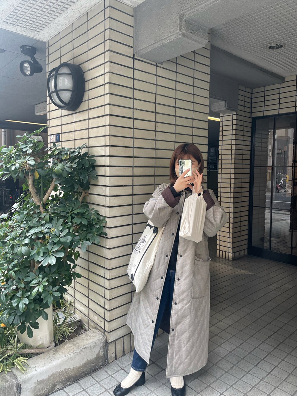 ブラウン系のジャケット/アウター、ブルー系のデニムパンツ、ブラック系のニット/セーターを着用したレディースの冬コーディネートの2枚目の写真