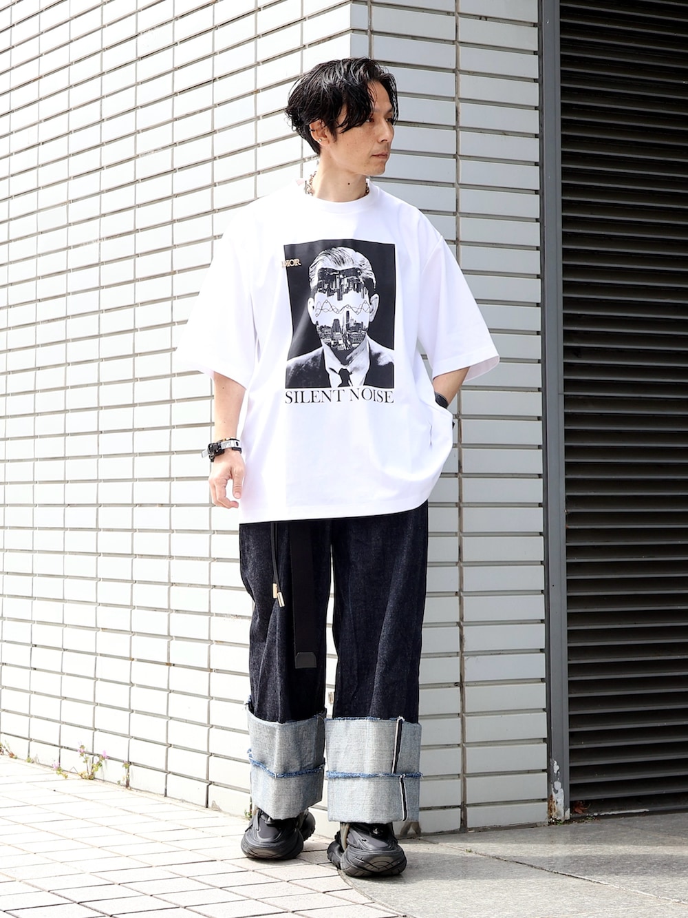 ブラック系のスニーカー、ブルー系のデニムパンツ、ブラック系のボストンバッグを着用したメンズの秋コーディネートの2枚目の写真