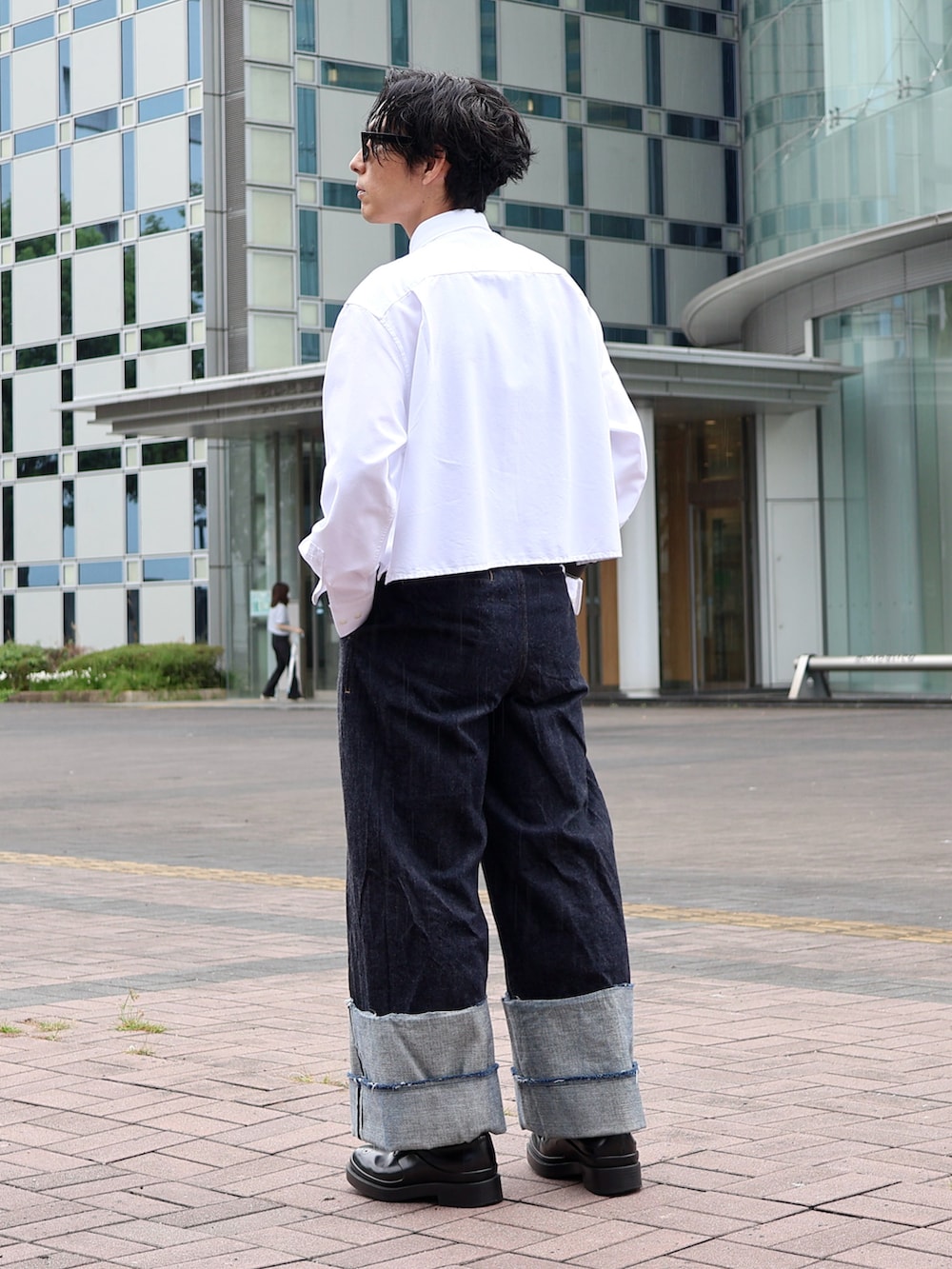 ブルー系のデニムパンツ、ブラック系のドレスシューズ、ブラック系のサングラスを着用したメンズの秋コーディネートの2枚目の写真