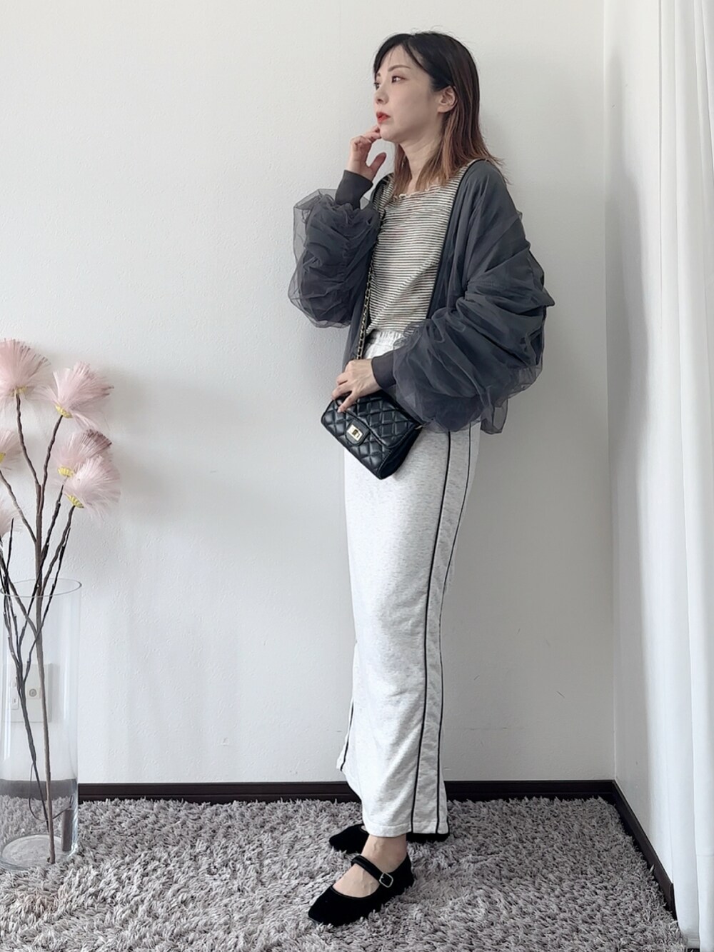グレー系のブルゾン、ホワイト系のTシャツ/カットソー、ブラック系のショルダーバッグを着用したレディースの秋コーディネートの2枚目の写真