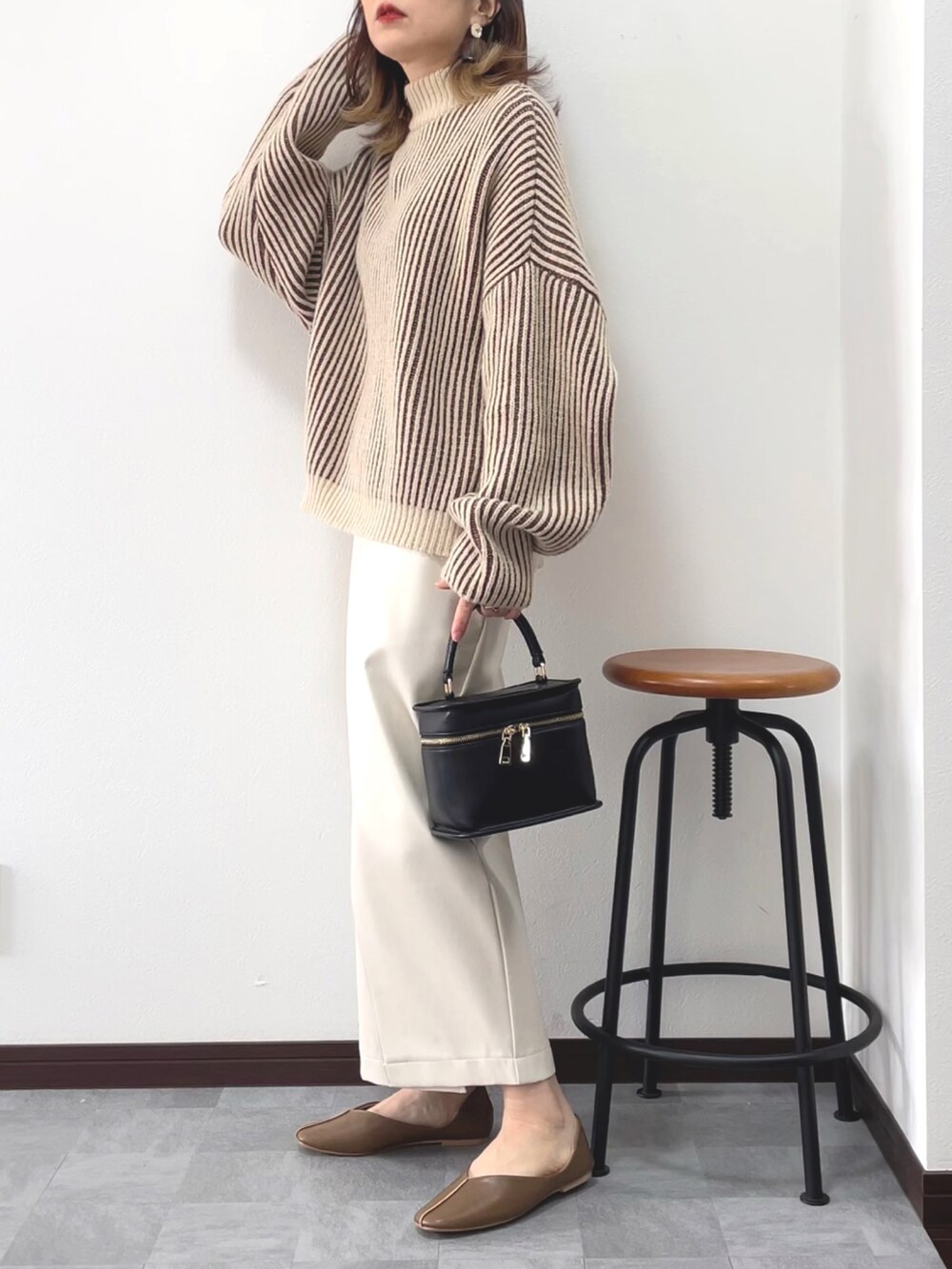 ブラウン系のニット/セーター、ホワイト系のスカート、ベージュ系のパンプスを着用したレディースの冬コーディネートの2枚目の写真