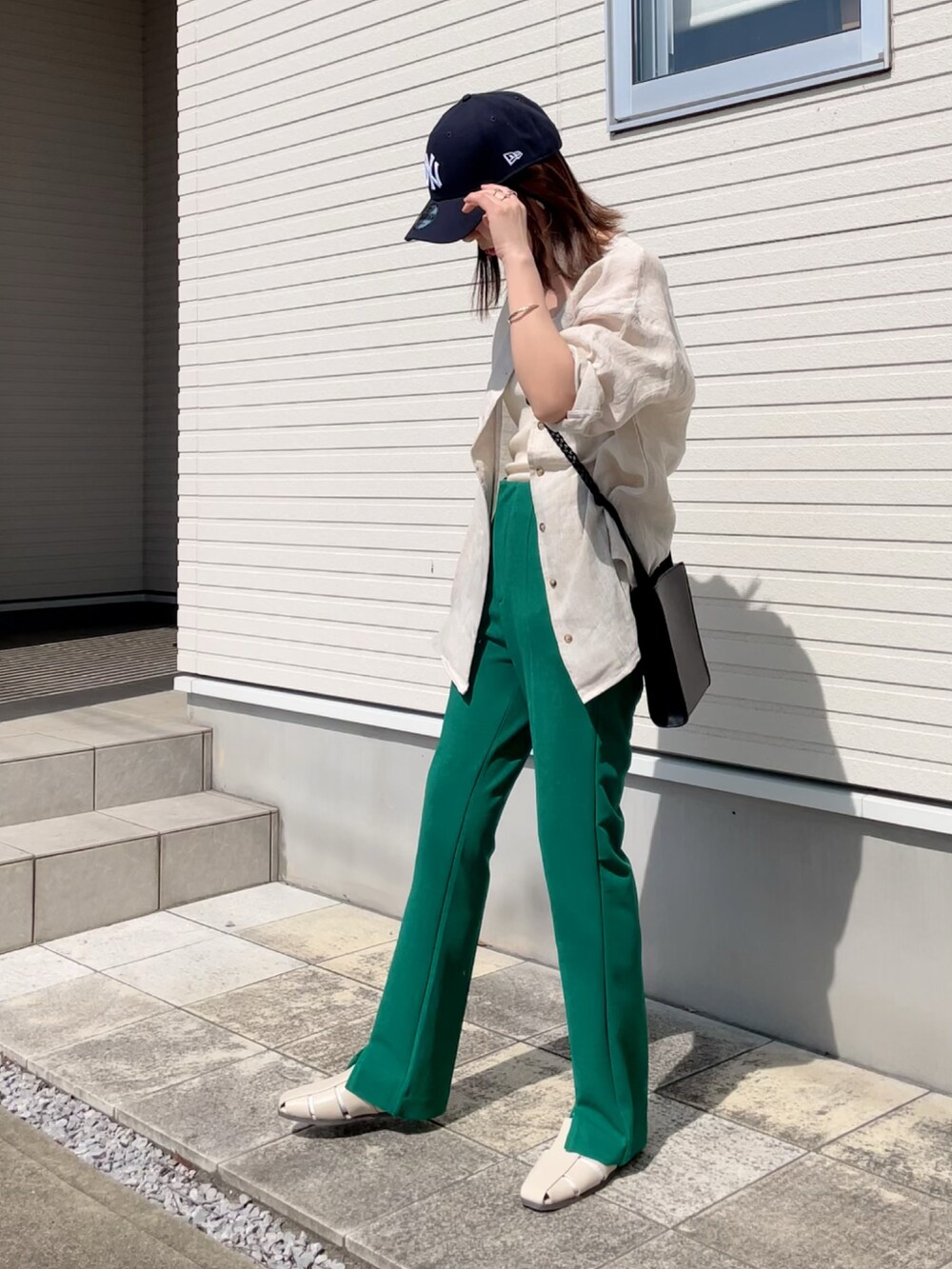 ベージュ系のシャツ/ブラウス、グリーン系のスラックス、ベージュ系のサンダルを着用したレディースの春コーディネートの2枚目の写真